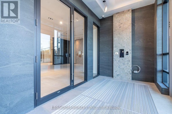 Entrance area with large glass doors, stone walls, and metal grate. - 2005 - 225 Malta Avenue, Brampton