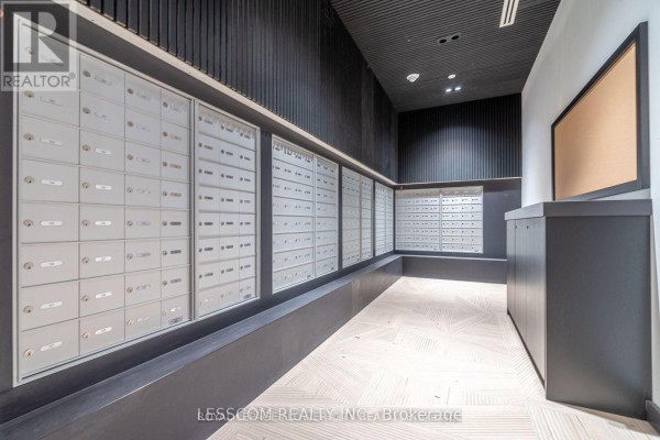 Hallway with rows of silver mailboxes, dark walls, and wooden floor. - 2005 - 225 Malta Avenue, Brampton