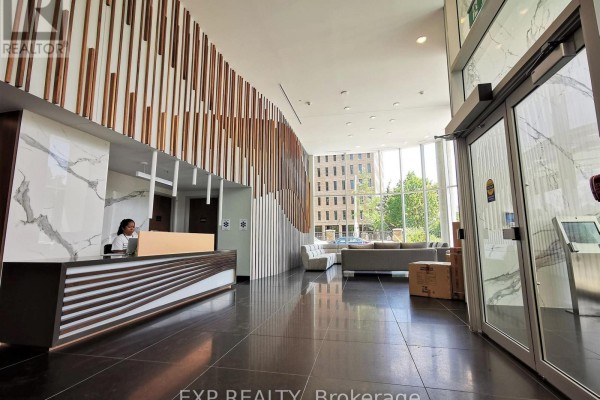 Building lobby with marble reception desk, wood slat walls, and modern seating area. - 2005 - 805 Carling Avenue, Ottawa
