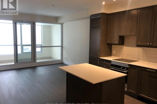 Open concept kitchen and living area with dark cabinets, island, and large windows. - 2005 - 9075 Jane Street, Vaughan