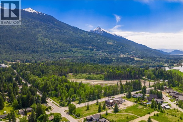 Aerial view of Revelstoke land with mountains and trees under a blue sky. - 2006 Lanzo Lane, Revelstoke