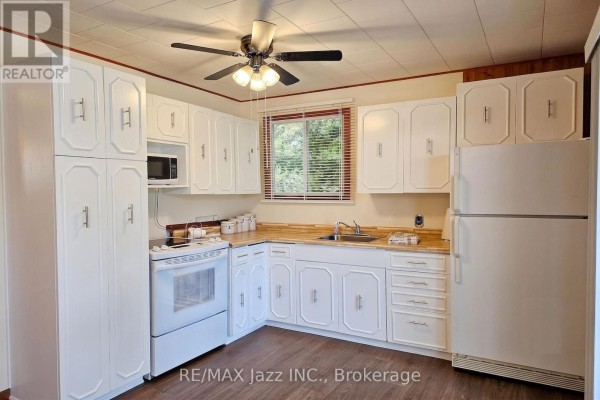 Kitchen with white cabinets, a white stove, and a wooden countertop. - 2006 South Beaver Lake Lane, Minden Hills