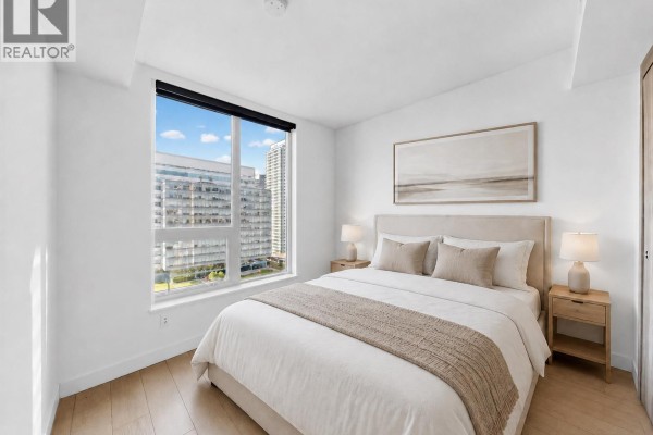 Bedroom with a queen-size bed, bedside tables, and a window facing other apartment buildings. - 2007 433 Sw Marine Drive, Vancouver