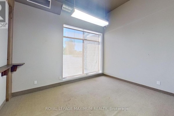 Interior space with beige carpet, large window, and exposed ceiling ductwork. - 2007 Commerce Pk Drive, Innisfil