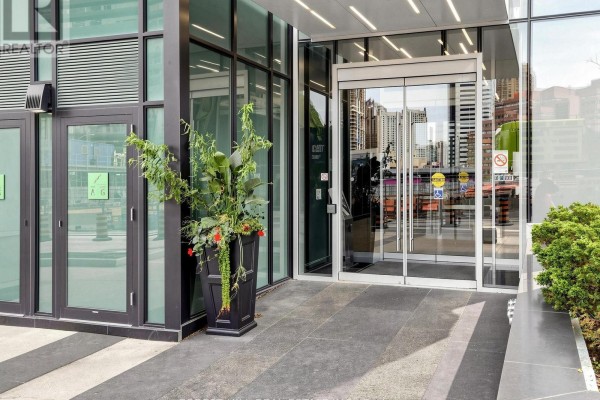 Exterior entrance to a modern apartment building with double glass doors and potted plants. - 2008 - 9 Bogert Avenue, Toronto