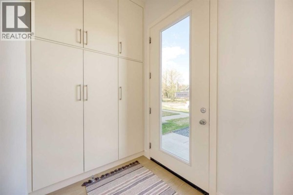 Living room featuring white walls, light wood floors, and a closet with white doors. - 2008 26a Street Sw, Calgary