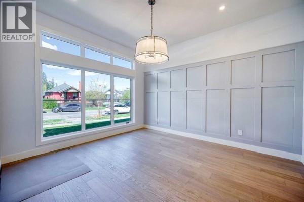 Open concept kitchen with a large island, stainless steel appliances, and white cabinetry. - 2008 26a Street Sw, Calgary