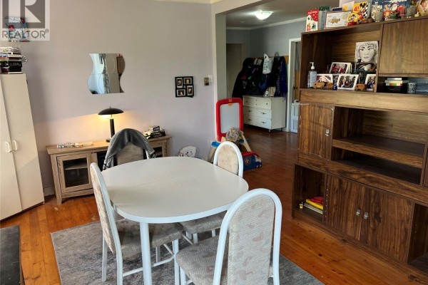 Living and dining area with a large wooden cabinet, a round dining table, and a dresser in the background. - 2008 Topping Street, Trail