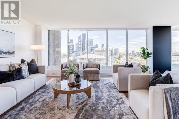Living room with white sofas, two armchairs, and a coffee table with a city view. - 2009 - 2045 Lake Shore Boulevard W, Toronto