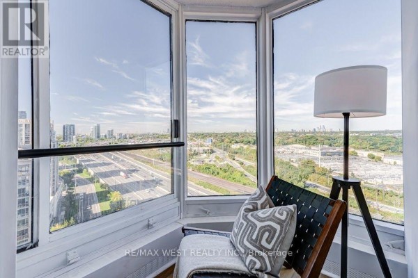 Living room featuring white sofas, armchairs, a patterned rug, and expansive city and water views. - 2009 - 2045 Lake Shore Boulevard W, Toronto