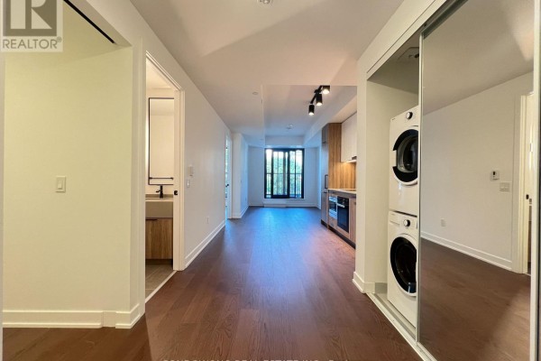 Open concept living and kitchen area with hardwood floors and city view balcony. - 518 - 91 Montclair Avenue, Toronto