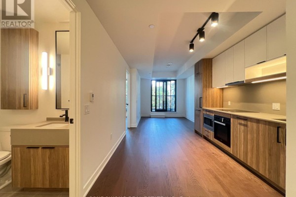 View of kitchen and living area with ample natural light and access to balcony. - 518 - 91 Montclair Avenue, Toronto