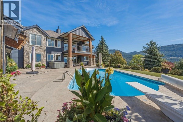 Swimming pool and patio area with a view of the lake and mountains. - 2009 Apex Court, Vernon
