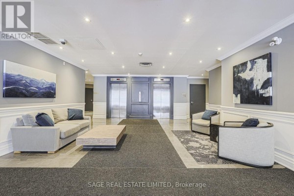 Apartment building lobby with two elevators, seating areas, and artwork on walls. - 201 - 111 Merton Street S, Toronto