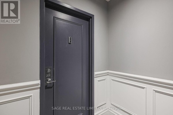 Dark grey apartment door with number 201 and silver handle, in a hallway. - 201 - 111 Merton Street S, Toronto