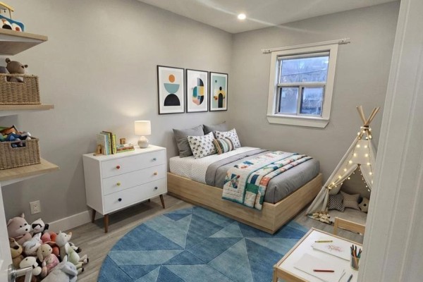 A child's bedroom with a twin bed, a teepee, a small desk, and colorful artwork on the wall. - 201 - 1566 Avenue Road, Toronto