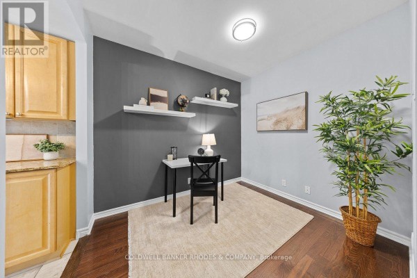 A compact home office space with a desk, chair, and dark gray accent wall. - 201 - 200 Lett Street, Ottawa