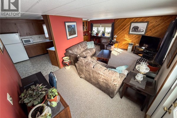 Open living area with kitchen access, wooden accents, and cozy seating - 201 - 203 4th Avenue, Climax