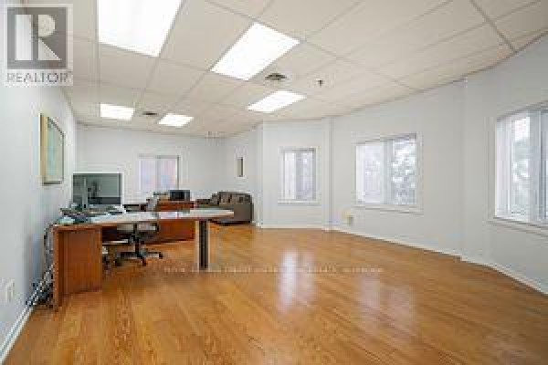 Office space with wood floors, desk with computer, sofa, and large windows. - 201 - 335 Renfrew Drive, Markham