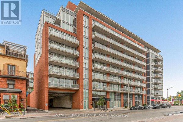 Corner view of a modern red brick apartment building with balconies and large windows. - 201 - 354 Gladstone Avenue, Ottawa