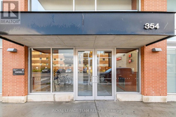 Glass double doors with the building number 354 above, flanked by brick. - 201 - 354 Gladstone Avenue, Ottawa