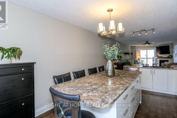 Aerial view of a waterfront townhouse complex with decks, stairs, and a dock on the lake. - 201 - 43 Olive Crescent, Orillia
