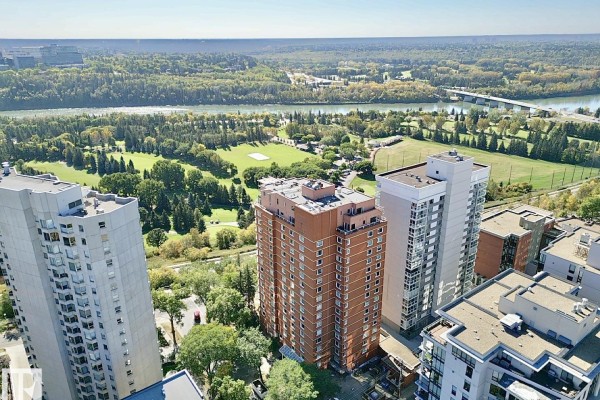 Aerial view of the brick apartment building surrounded by trees and a golf course. - #201 10010 119 St Nw, Edmonton