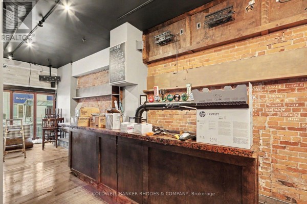 Interior view of a bar area with a wooden counter, beer taps, and brick walls. - 201 Queen Street, Ottawa