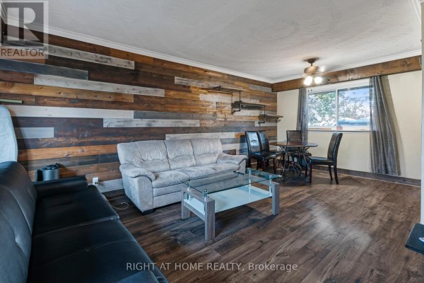 Interior hallway with wood flooring, barn door, and stacked washer/dryer. - 201 Steel Street, Barrie