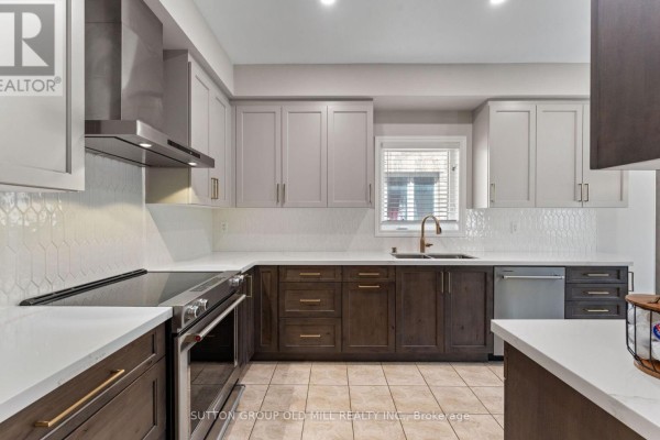 Modern kitchen with white countertops, two-toned cabinetry, stainless steel appliances, and a tiled backsplash. - 201 Vellore Park Avenue, Vaughan