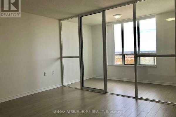 Bedroom with mirrored closet doors and large windows offering an urban vista. - 2010 - 2627 Mccowan Road, Toronto