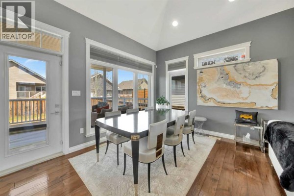 Dining room with a dark wood table, upholstered chairs, and a view of the backyard. - 2010 56 Avenue, Lloydminster