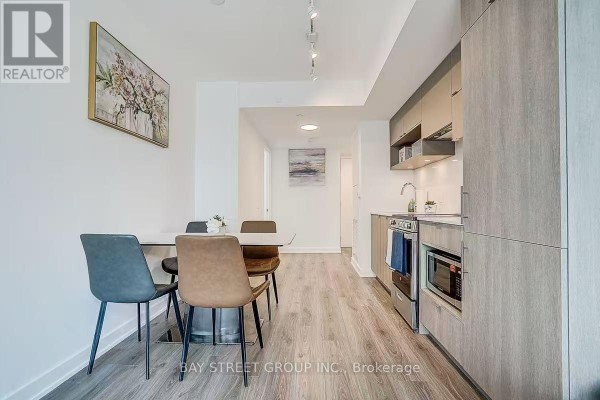 Dining area with a table and four chairs adjacent to the modern kitchen. - 2011 - 100 Queen Street E, Toronto