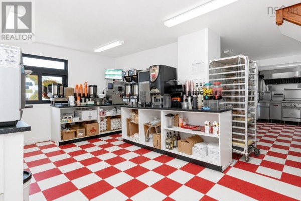 Interior commercial space with red and white checkered floors, a beverage station, kitchen equipment, and a baking rack. - 2011 Louisbourg Highway, Mira Road