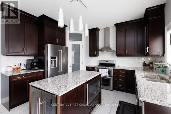 Kitchen with dark cabinets, granite island, and stainless steel appliances - 2014 Ballymote Avenue London North