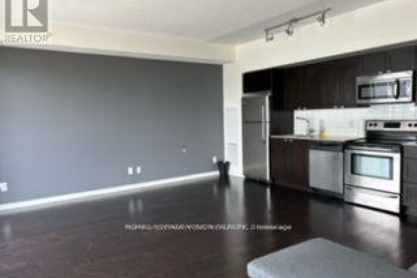 Open concept living area with dark hardwood floors and a grey accent wall. - 2016 - 105 The Queensway Street, Toronto