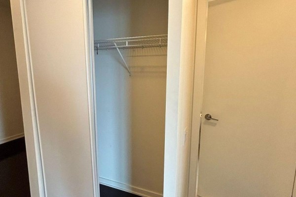 Empty walk-in closet with a metal wire shelving unit and sliding doors. - 2016 - 105 The Queensway Street, Toronto
