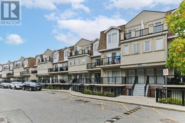 Street view of a townhouse complex with multiple units and parking spaces. - 2016 - 3035 Finch Avenue W, Toronto