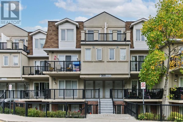 Close-up exterior view of beige townhouses with balconies and peaked roofs. - 2016 - 3035 Finch Avenue W, Toronto