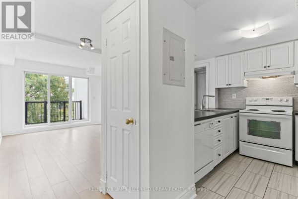 Interior view of a white kitchen with appliances and a doorway to a living area. - 2016 - 3035 Finch Avenue W, Toronto