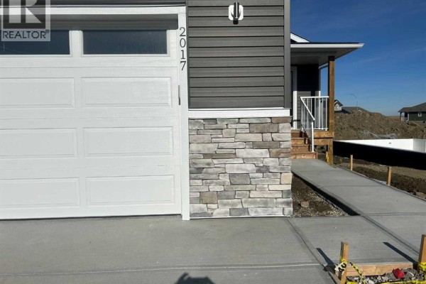 Close-up of the front exterior showing the garage and entrance - 2017 30 Avenue, Nanton