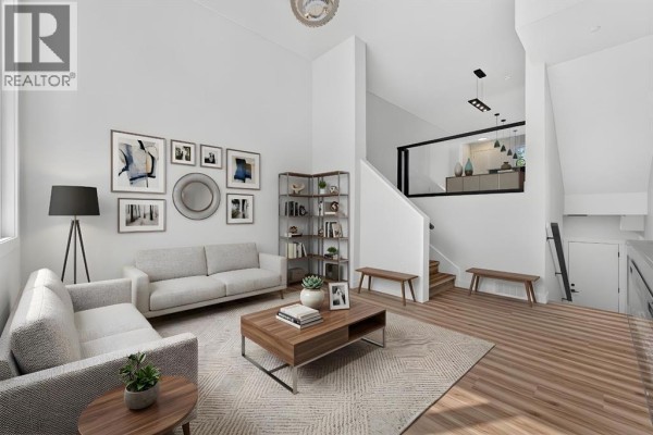 Living room with two sofas, a coffee table, artwork, a bookshelf, and a view into an upstairs hallway. - 2018 12 Avenue Sw, Calgary