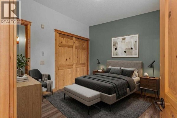 Covered balcony with wooden railing and metal artwork. - 202, 75 Dyrgas Gate, Canmore