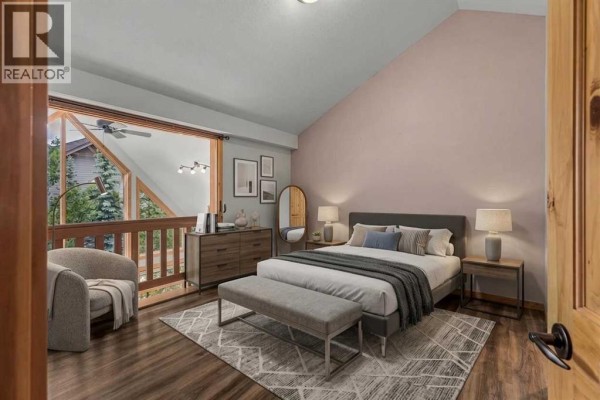 Living room with vaulted ceilings, large stone fireplace, and hardwood floors. - 202, 75 Dyrgas Gate, Canmore