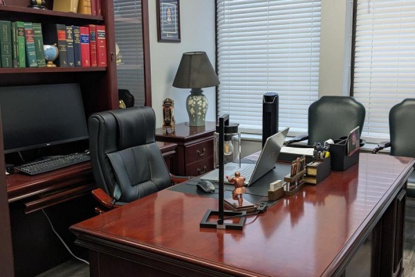 Lawyer's office desk with a computer, laptop, and decorative items. - 202 - 1150 Eglinton Avenue E, Mississauga