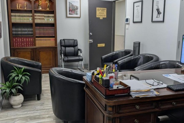 Law office with client seating, a large wooden desk, and bookshelves. - 202 - 1150 Eglinton Avenue E, Mississauga