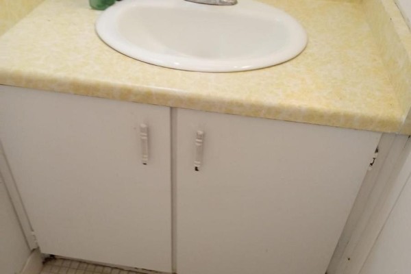 Bathroom sink with yellow countertop and white cabinetry - 202 - 25 Sunrise Avenue, Toronto