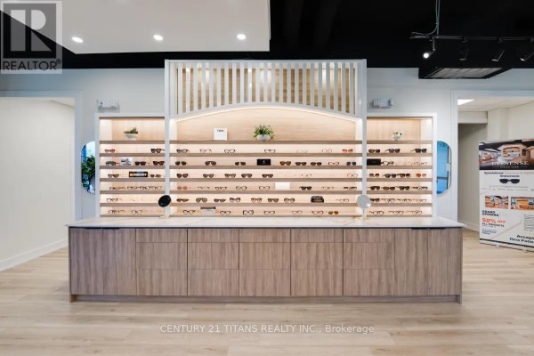 Close-up of a large display counter with multiple shelves showcasing eyewear and cabinetry below. - 202 - 40 Blowers Crescent, Ajax