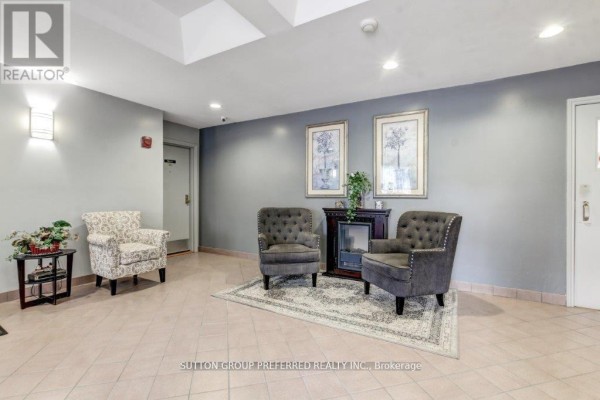 Lobby seating area with upholstered chairs, a rug, and decorative framed art. - 202 - 860 Commissioners Road E, London South