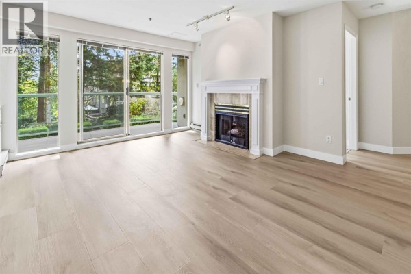 Entrance lobby with glass doors, tiled flooring, and seating area. - 202 1148 Westwood Street, Coquitlam